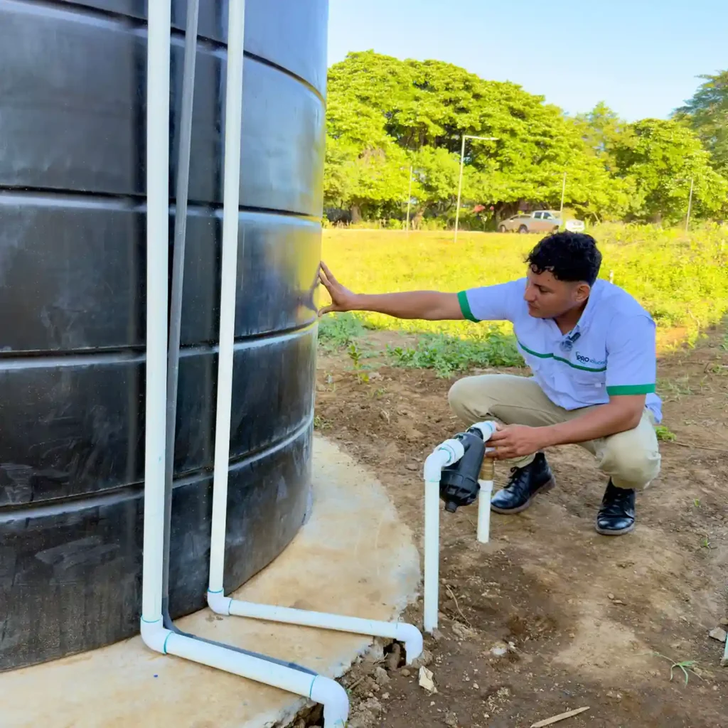 Técnico realizando instalación profesional de tanque de agua con conexión a tuberías en Nicaragua