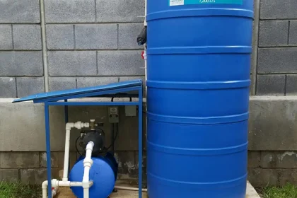 Tanque de agua vertical con sistema de bomba y conexión hidráulica instalado en vivienda